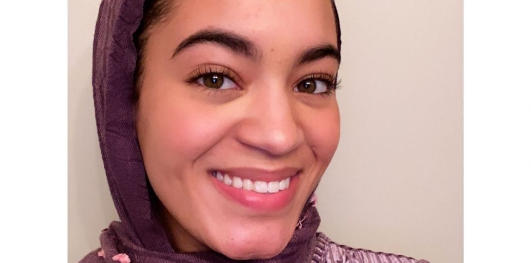 Zahrah Bennett, smiling while wearing a purple shirt and hijab.
